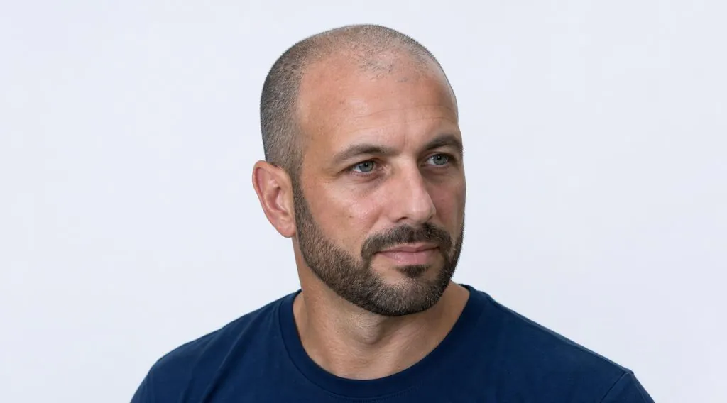 Buzz cut à 3 mm associé à une barbe courte et nette sur une calvitie avancée